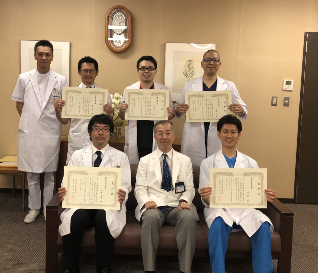 写真前段中央が佐田病院長、その左隣が松薗助教